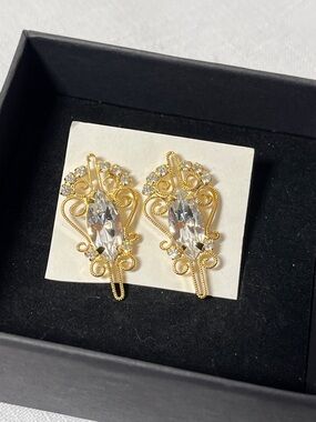 Vintage ornate gold-tone earrings with central marquise-cut rhinestones.